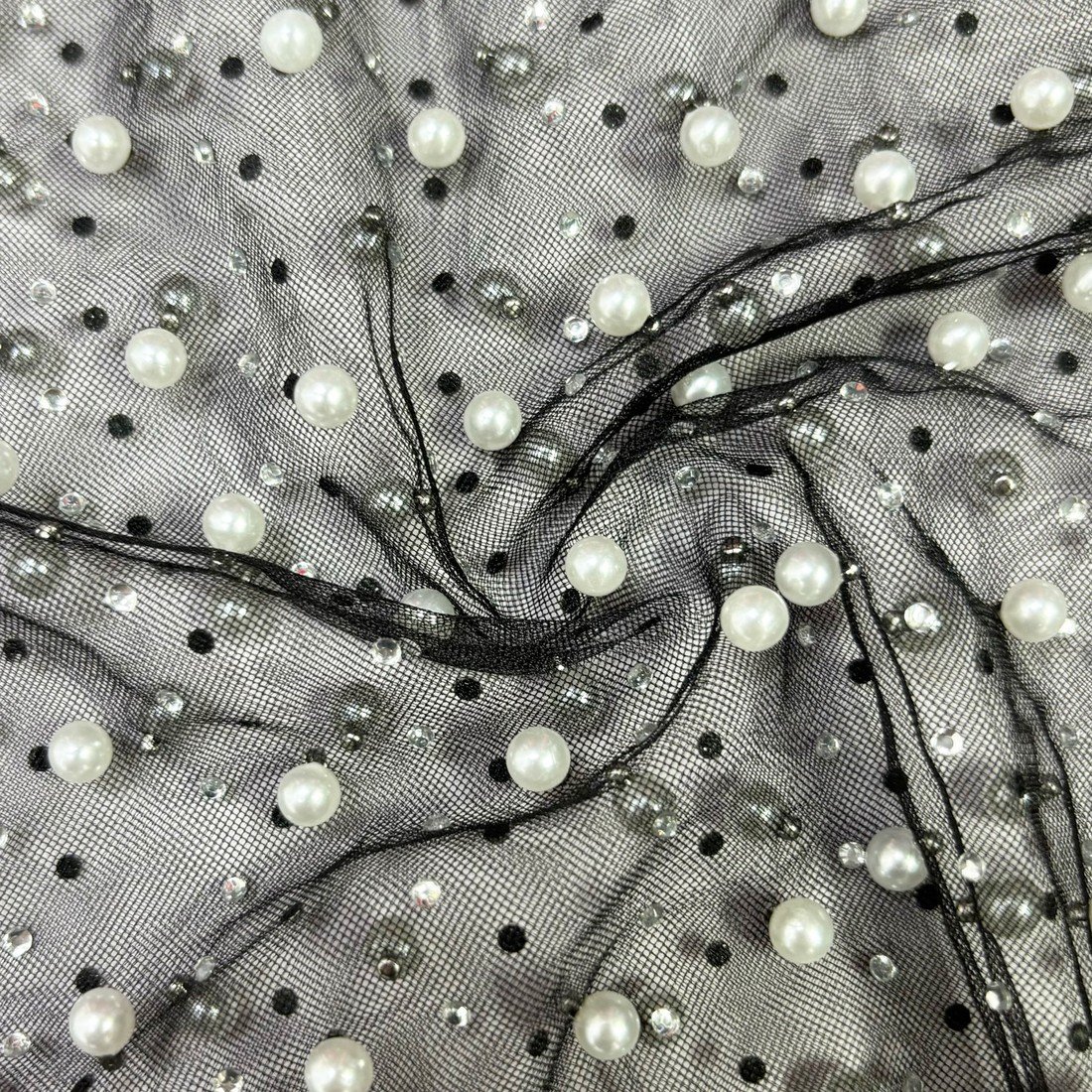 Clear close-up of pearl beadwork on black mesh
